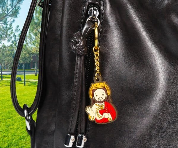 Jesus plush keychain attached to a bag in a park