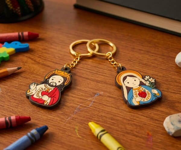 Virgin Mary and Jesus keychains on a desk